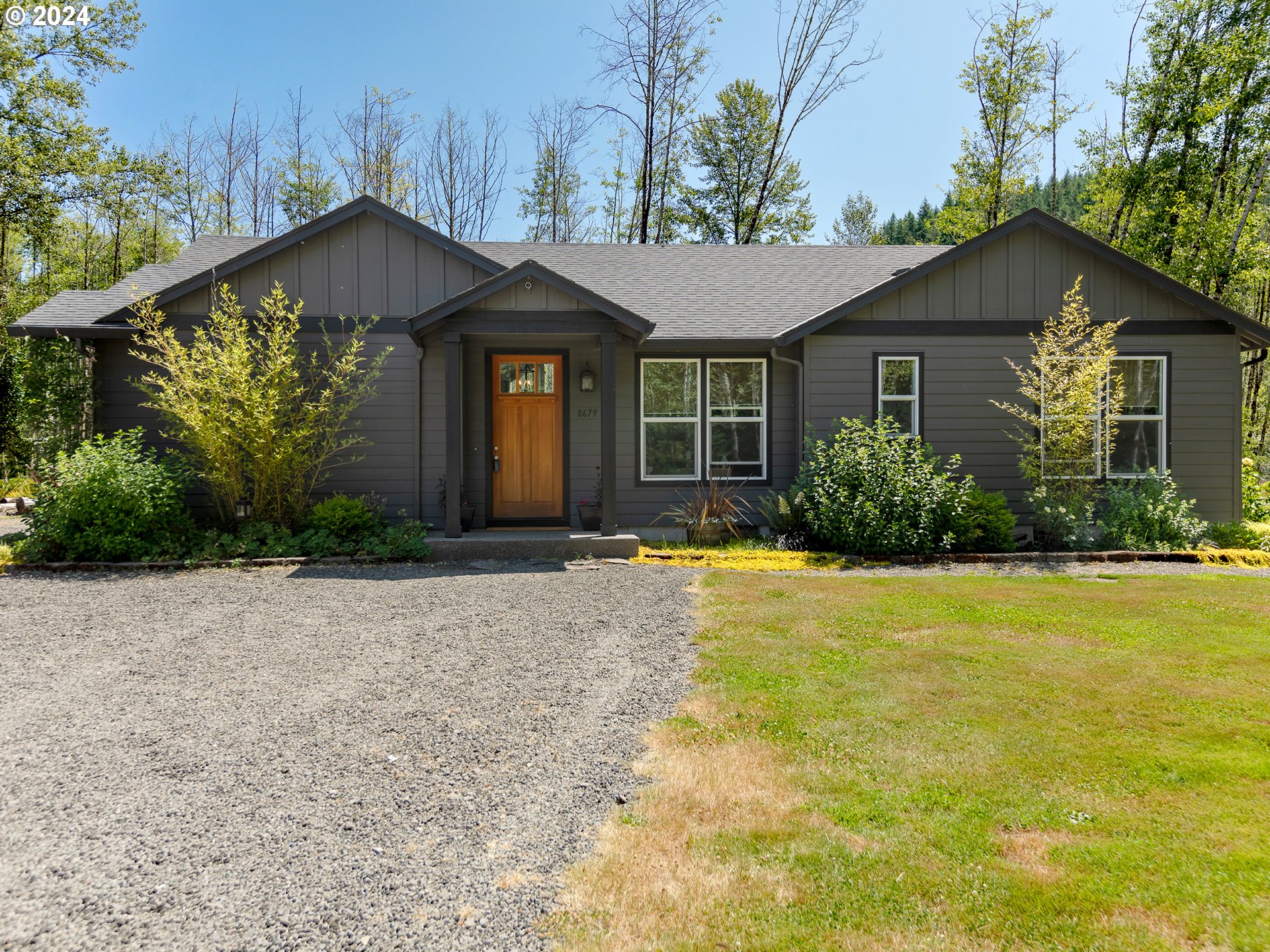 a front view of house with yard and trees around