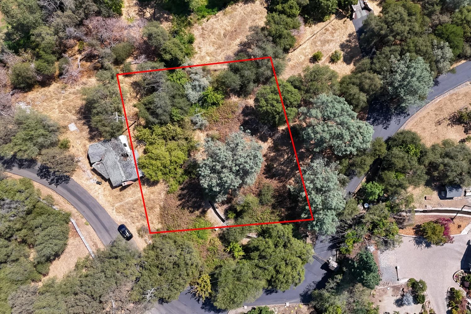 an aerial view of residential house with outdoor space and trees all around