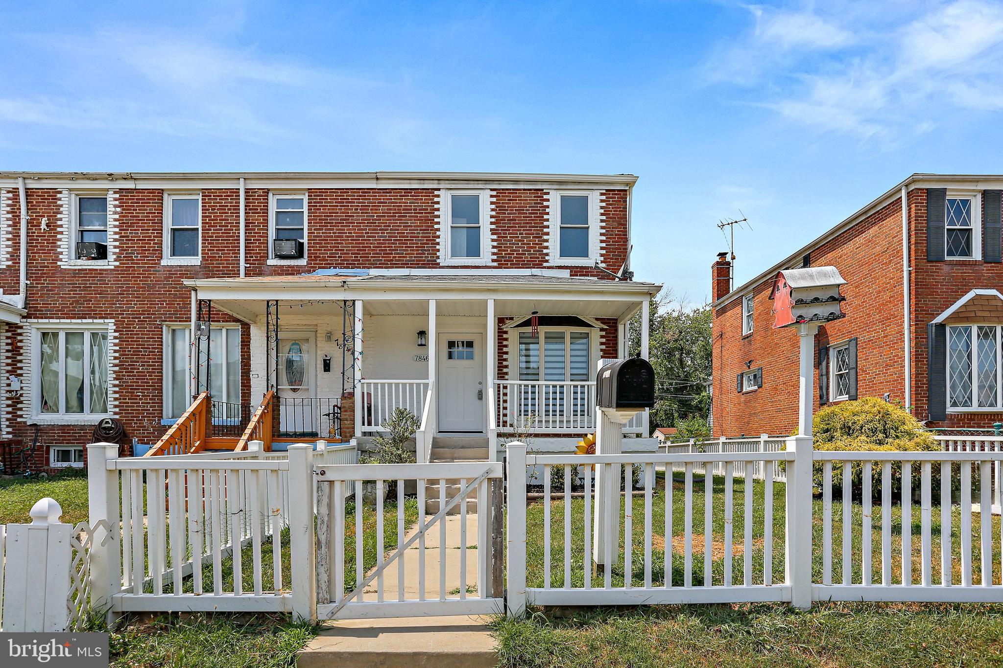 a view of a brick house with many windows and a fence