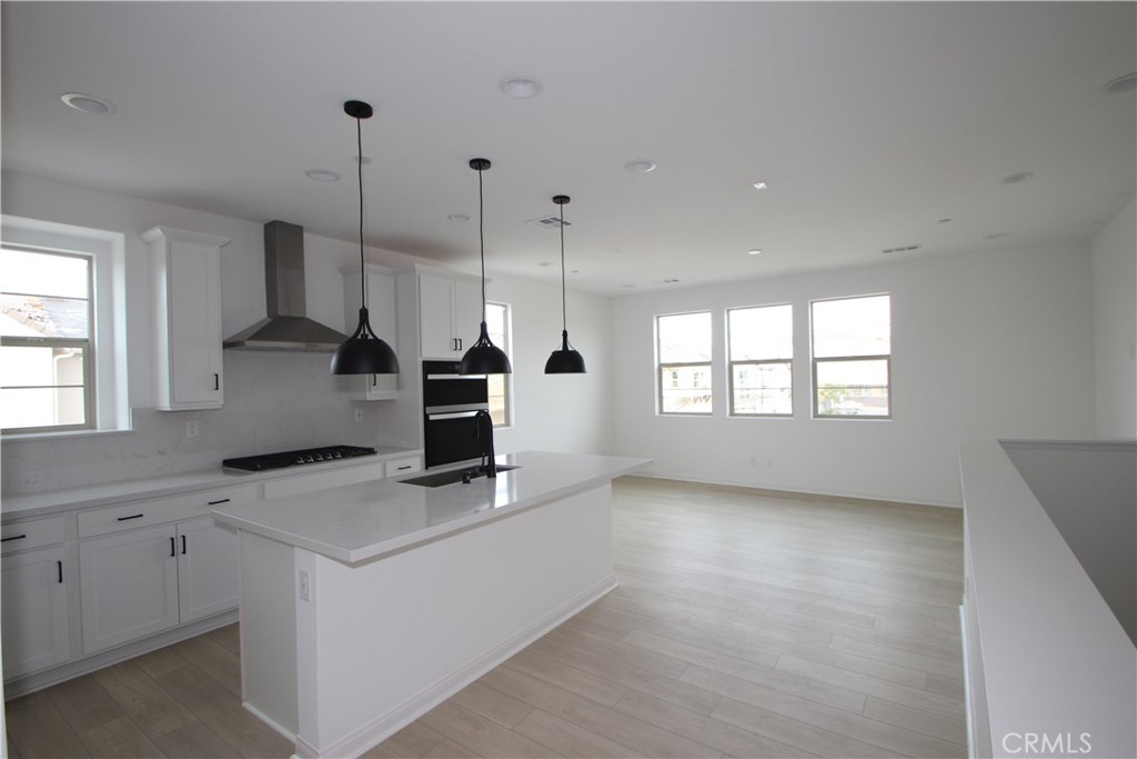 a kitchen that has a sink a window and a stove top oven