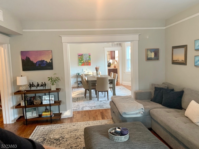 a living room with furniture and a flat screen tv with kitchen view