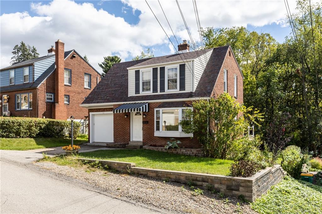 a front view of a house with a yard and potted plants