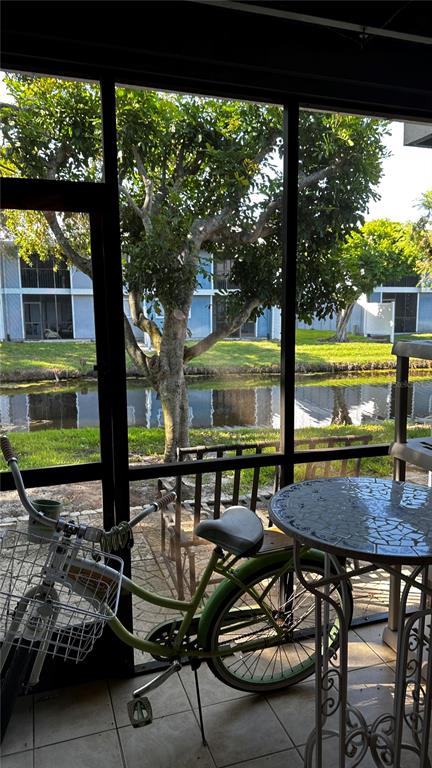 a view of a patio with table and chairs with wooden floor and floor to ceiling window