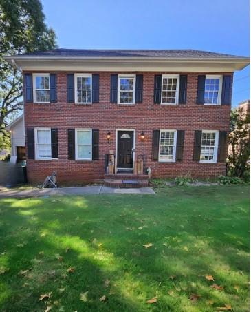 a brick house with a yard in front of it