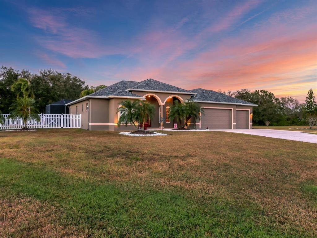 a front view of house with yard and trees in the background