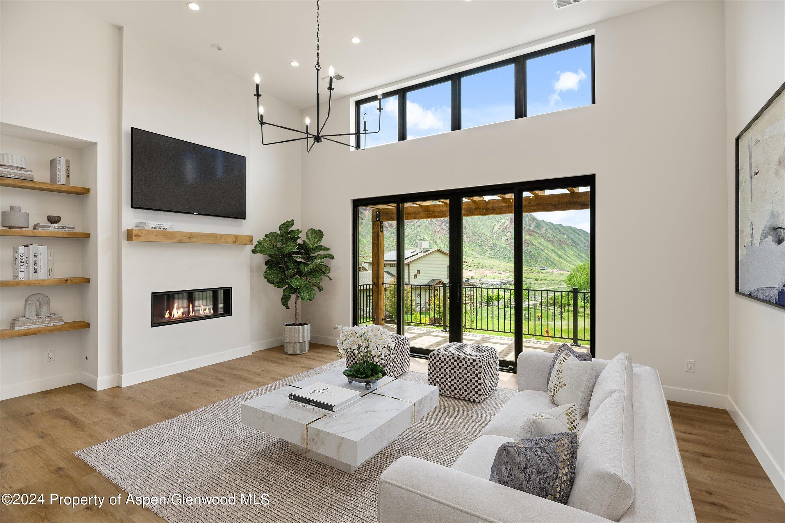 a living room with furniture a flat screen tv and a fireplace