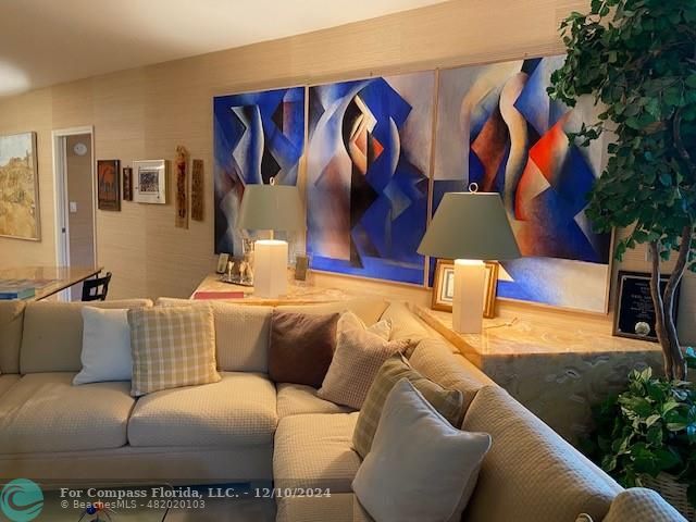 a living room with furniture and painting on the wall