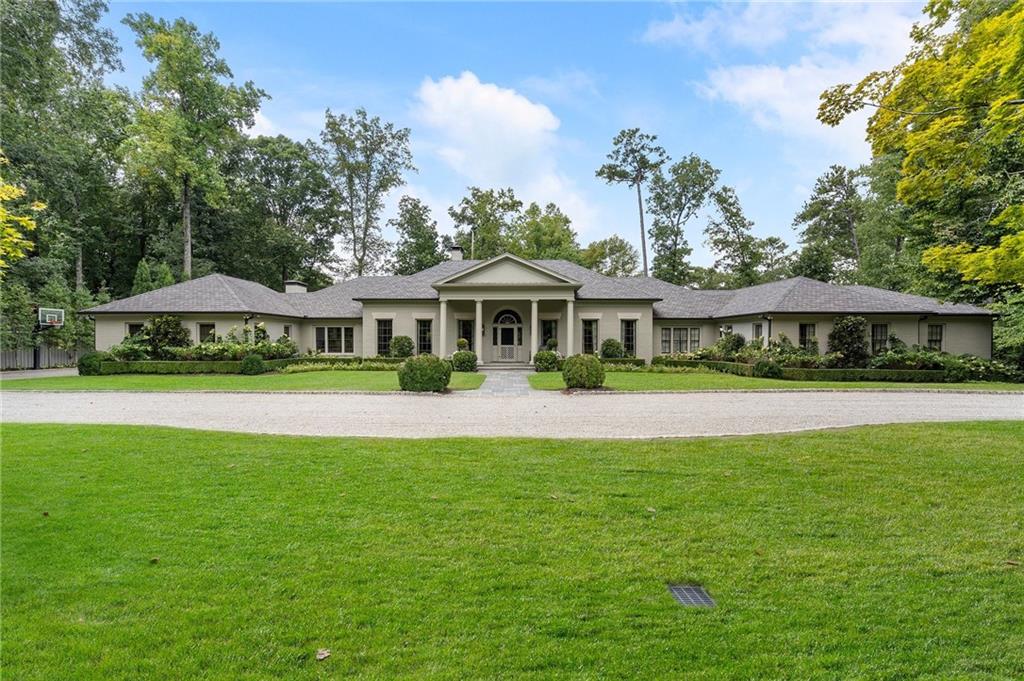 a front view of a house with yard and green space