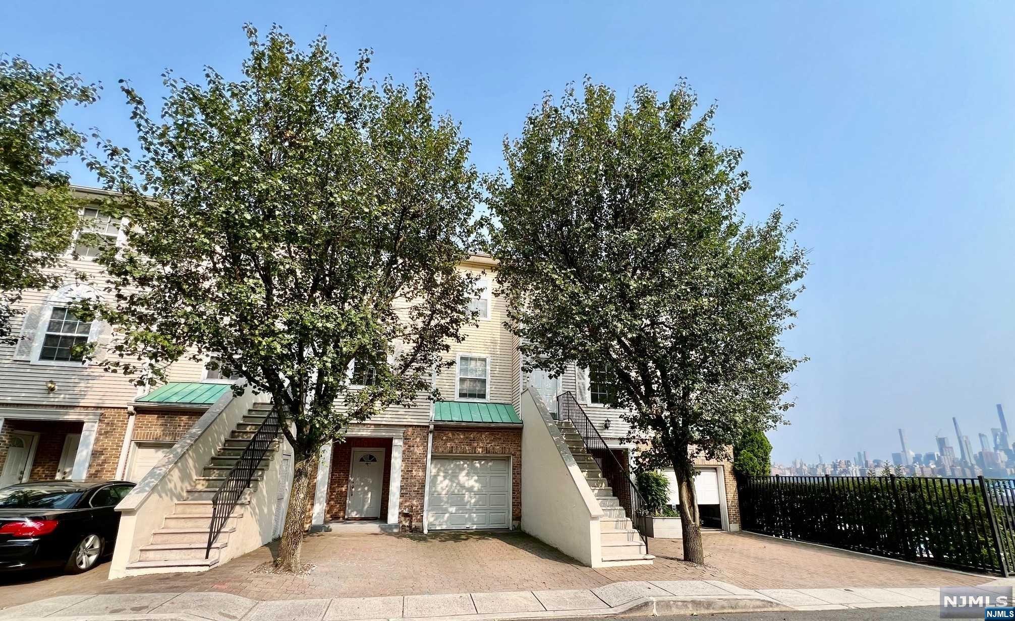 a front view of a house with a tree