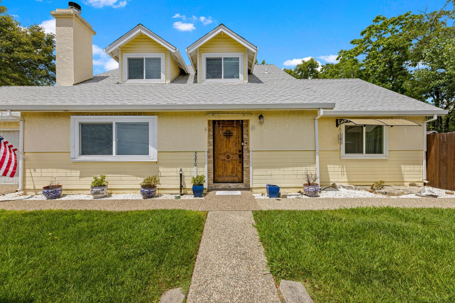 a front view of a house with sitting area and garden