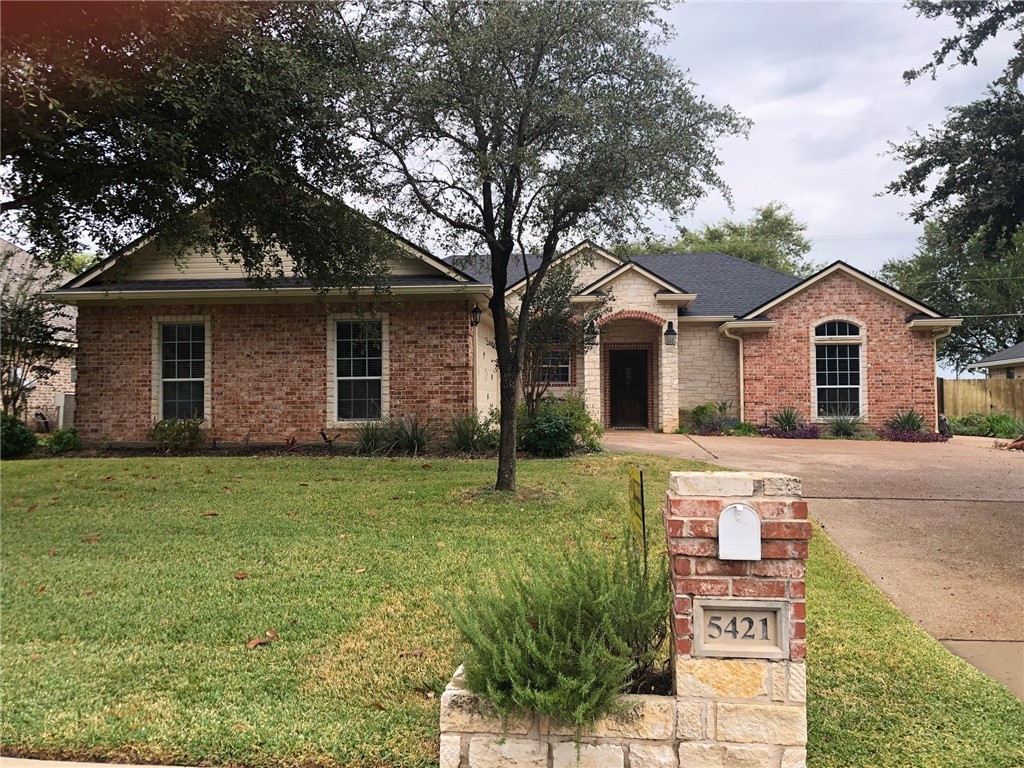 a front view of house with yard and green space