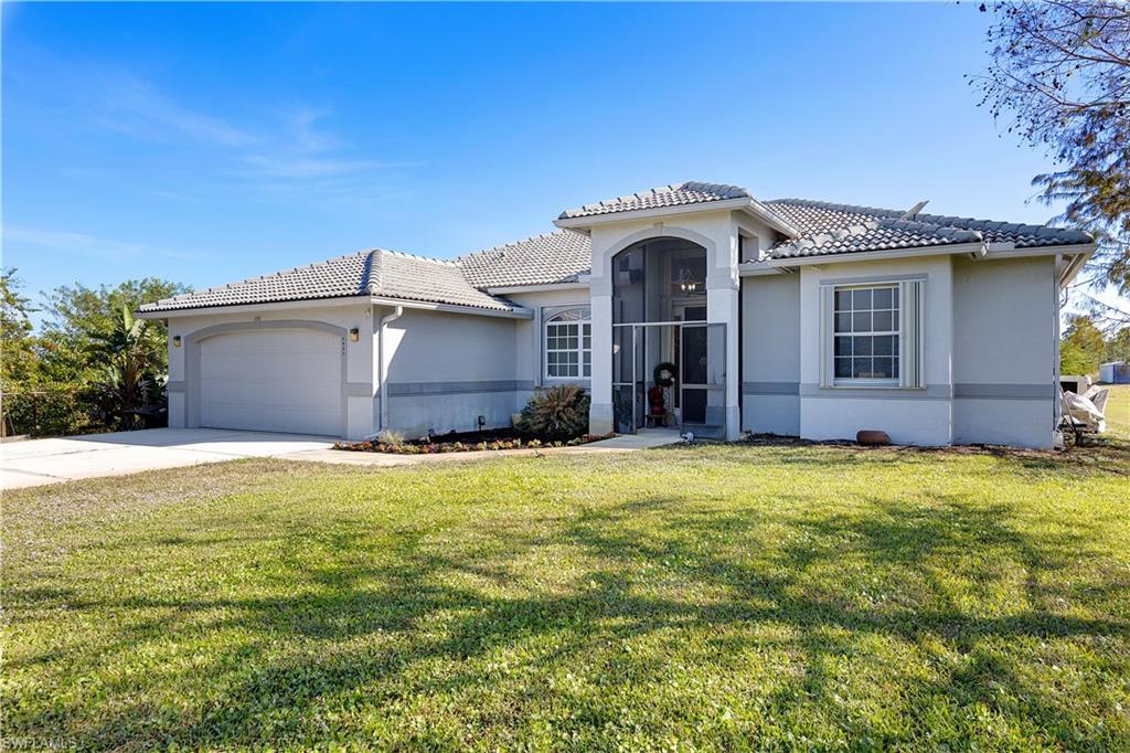 Mediterranean / spanish-style house with a front lawn and a garage