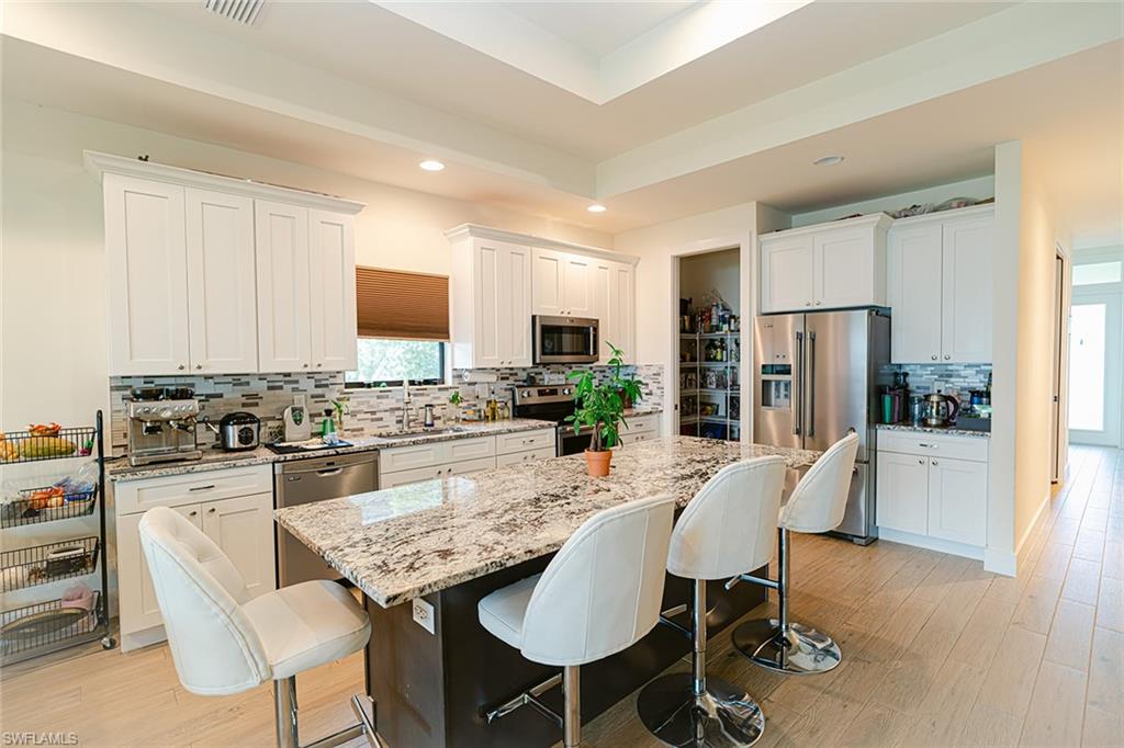 a kitchen with a dining table chairs and refrigerator