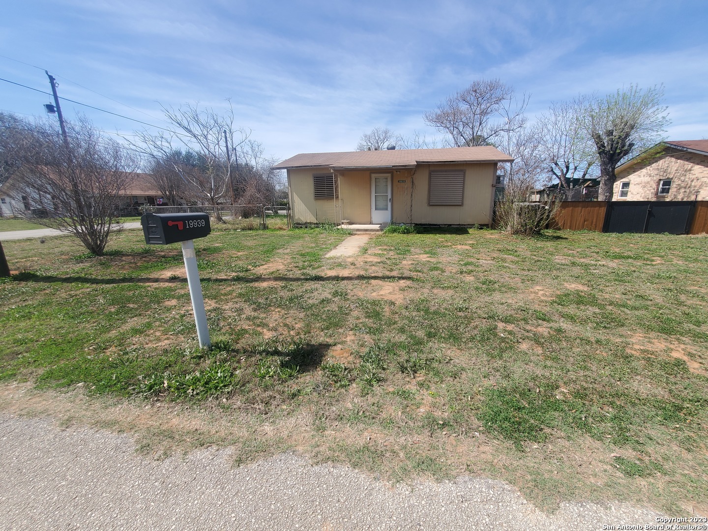 a view of a house with a yard and a large tree