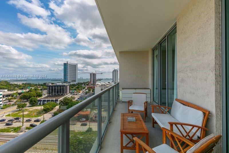 a city view from a balcony with furniture