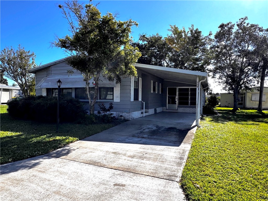 a front view of a house with a yard and trees