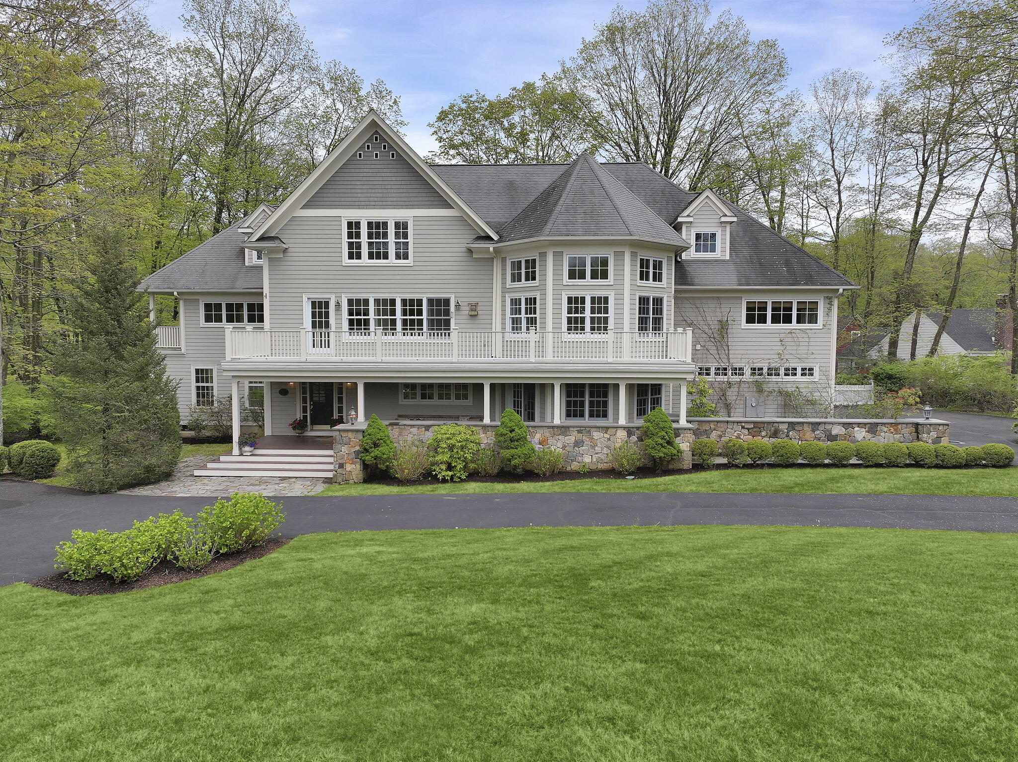 a front view of a house with a garden and trees