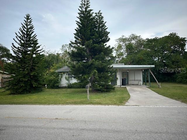 a view of a house with a yard and large trees