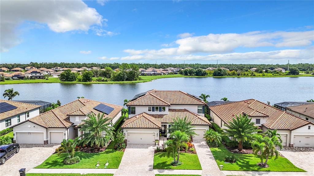 an aerial view of a house with outdoor space and lake view