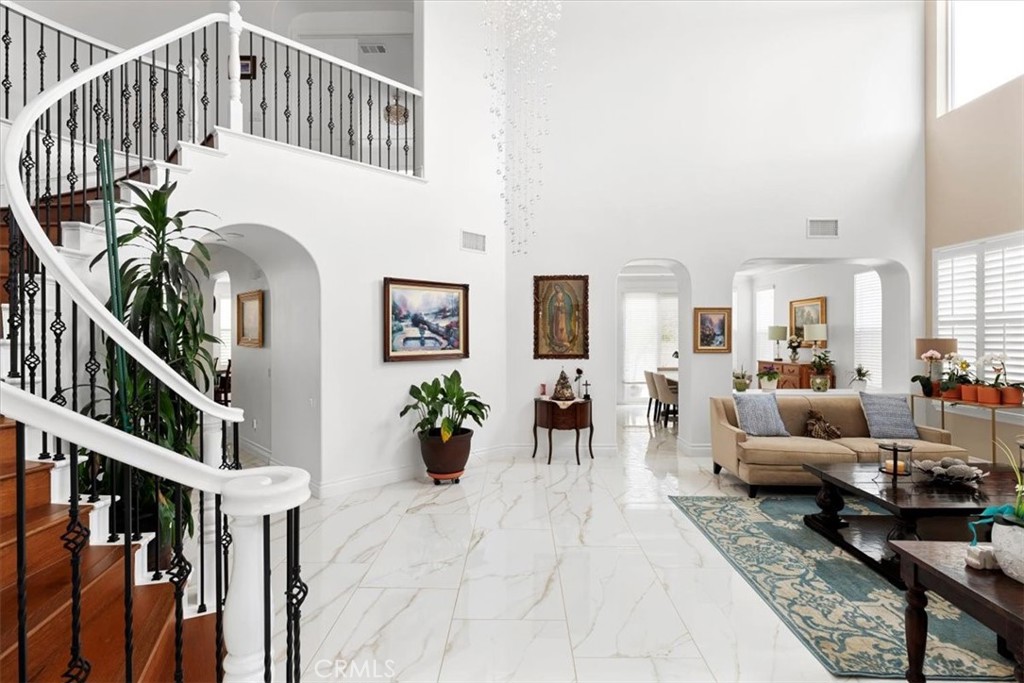 a living room with furniture flowers and a potted plant