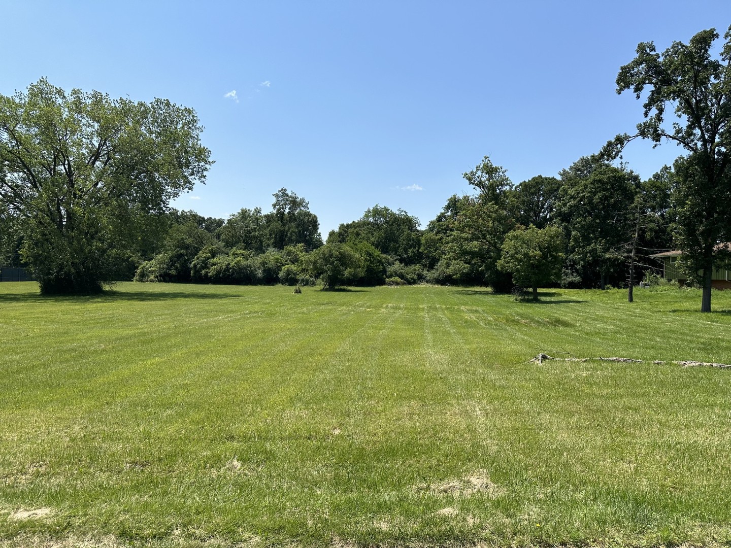 a view of a green field with wooden fence