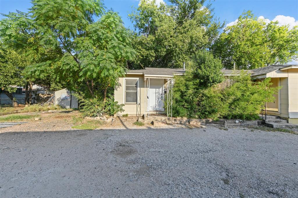 a view of a house with backyard and trees