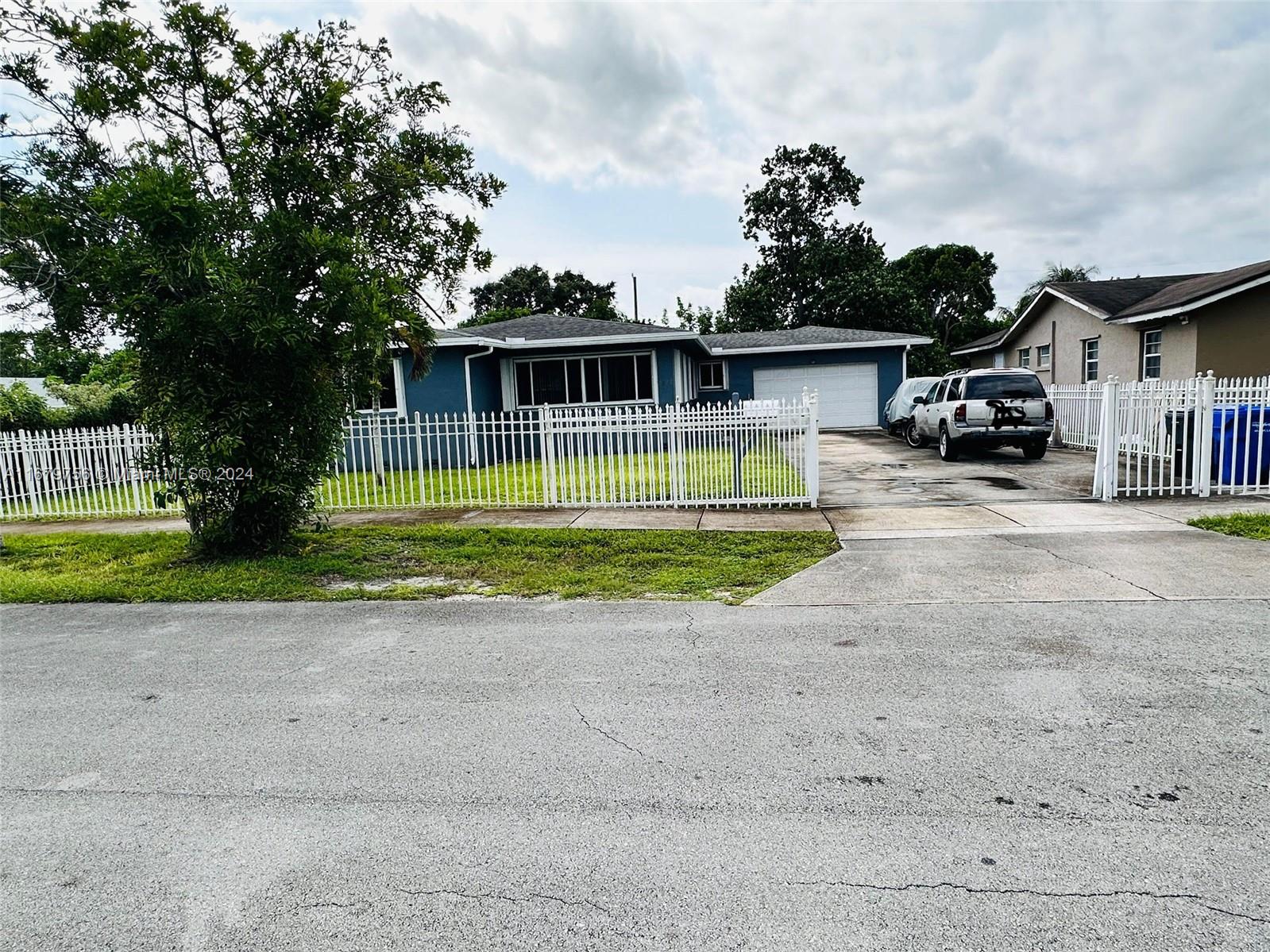 a view of a house with a yard and large trees