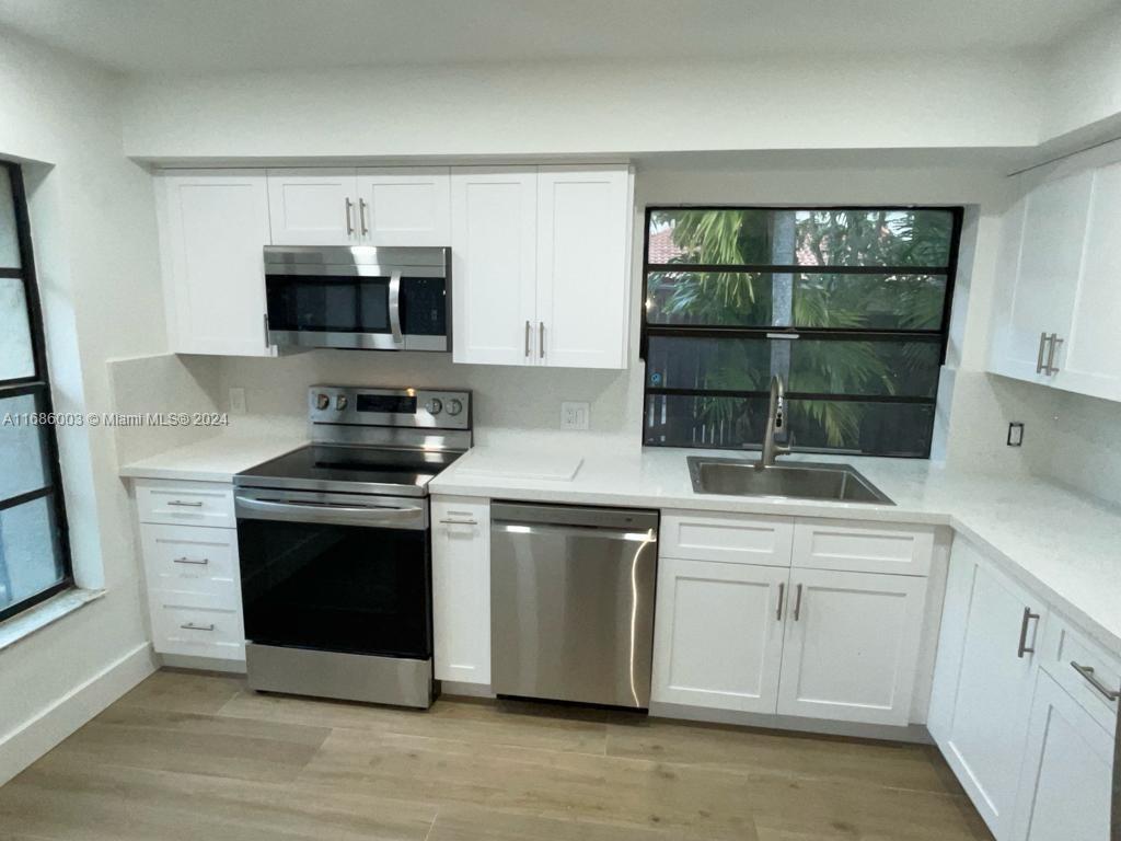 a kitchen with stainless steel appliances granite countertop a stove a microwave and a sink