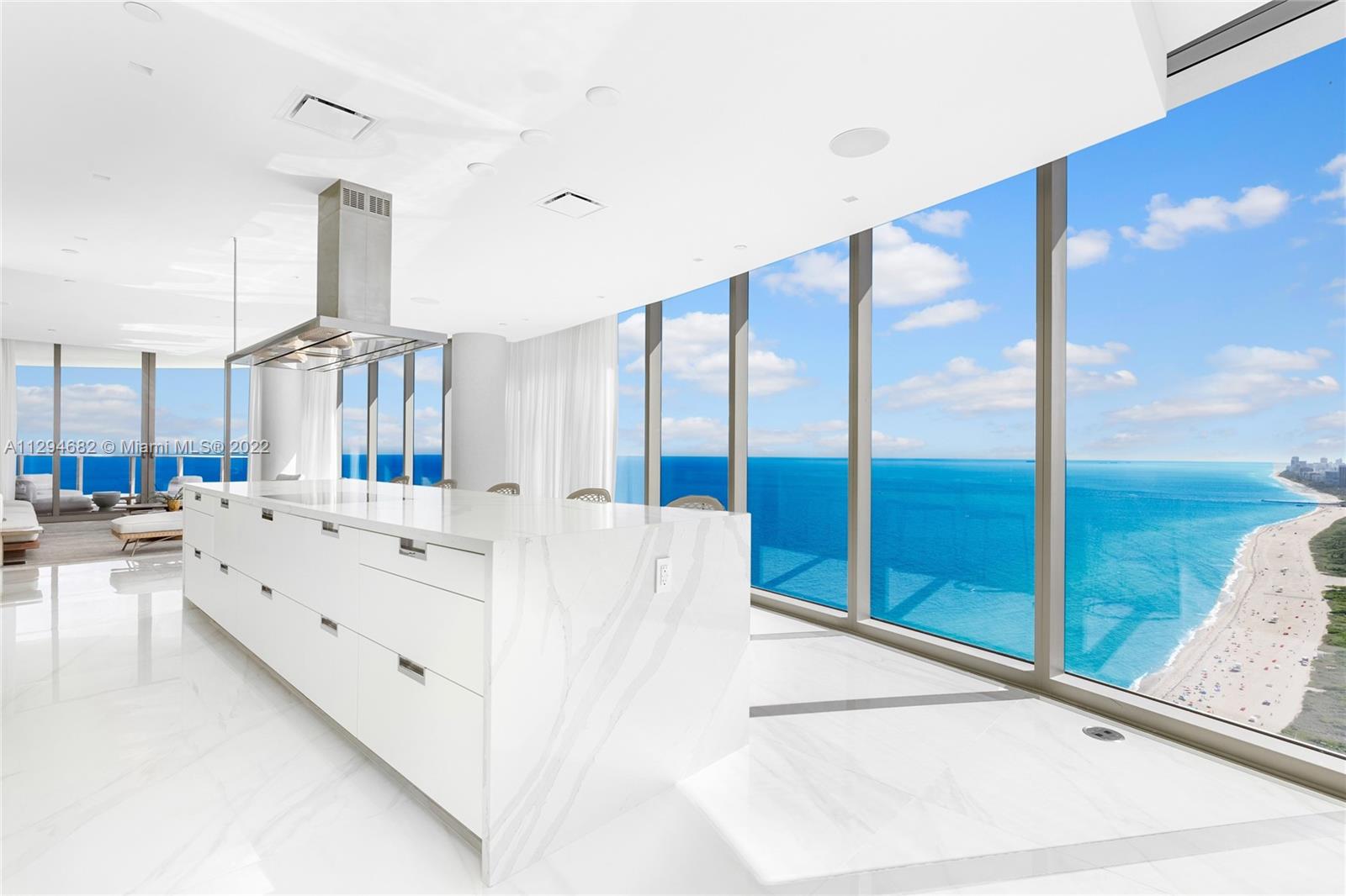 a large white kitchen with a large window and sink