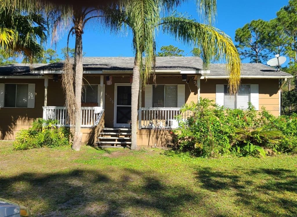 front view of house with a yard and potted plants