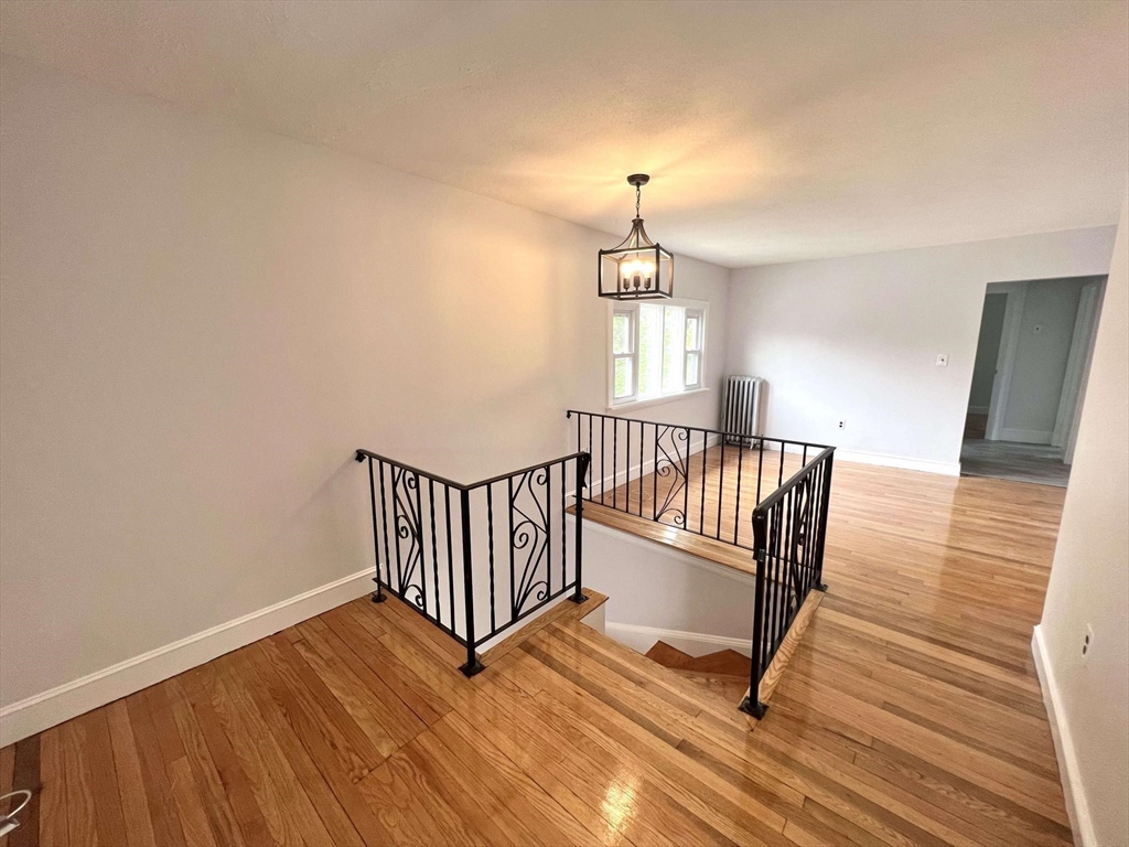 a view of a hallway with wooden floor and fence