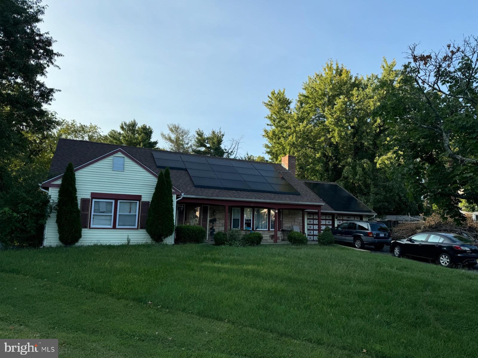 a front view of a house with a garden and trees