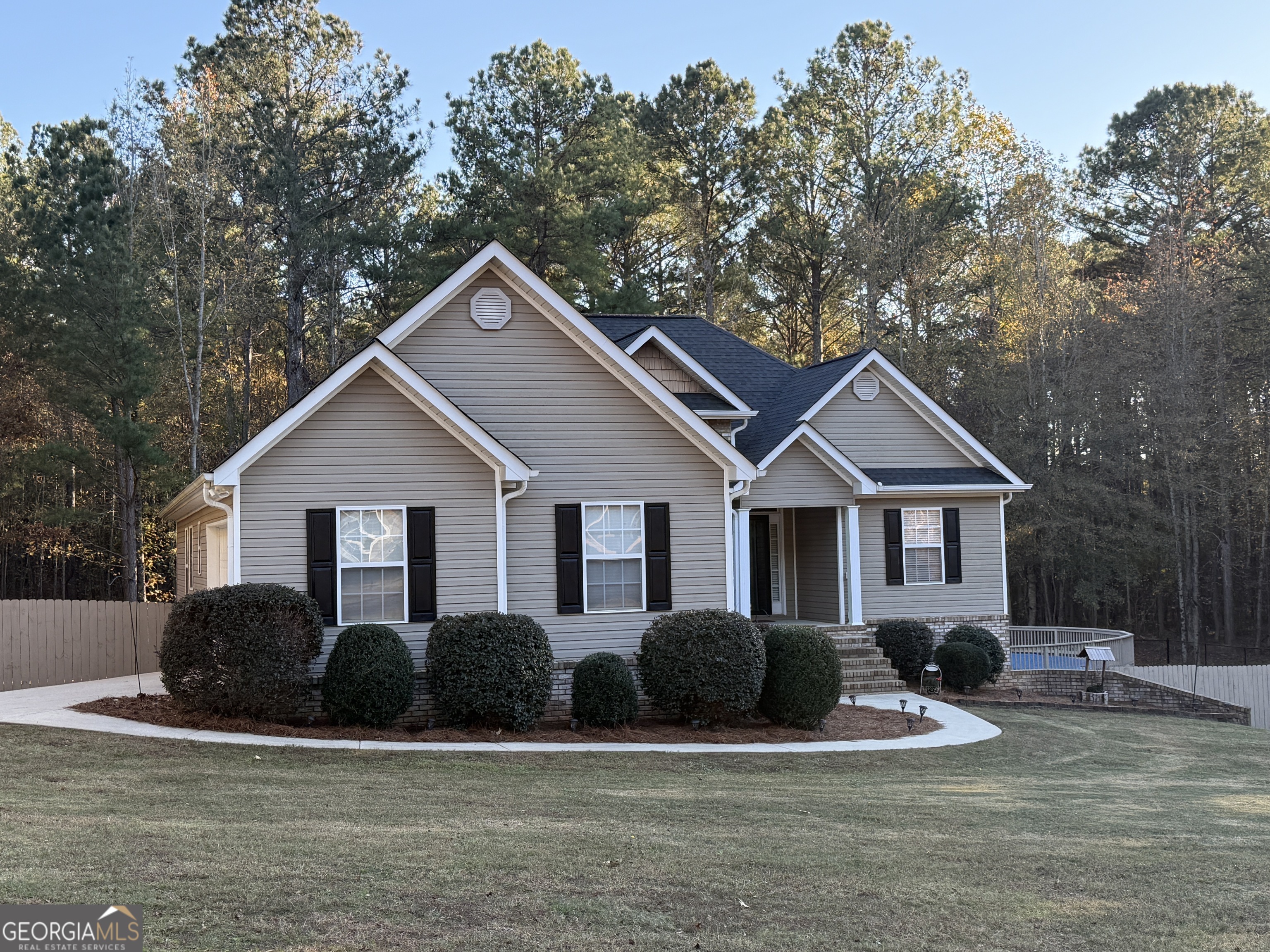 a front view of house with yard and trees in the background