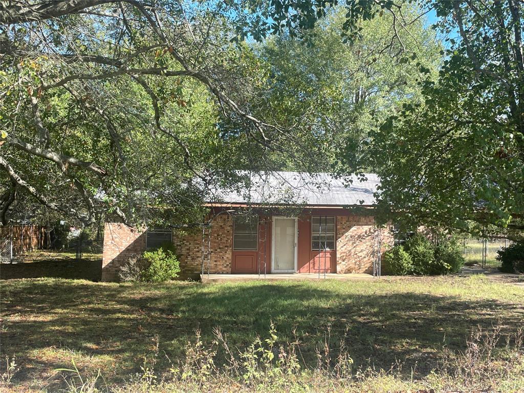 a view of a house with backyard and a tree