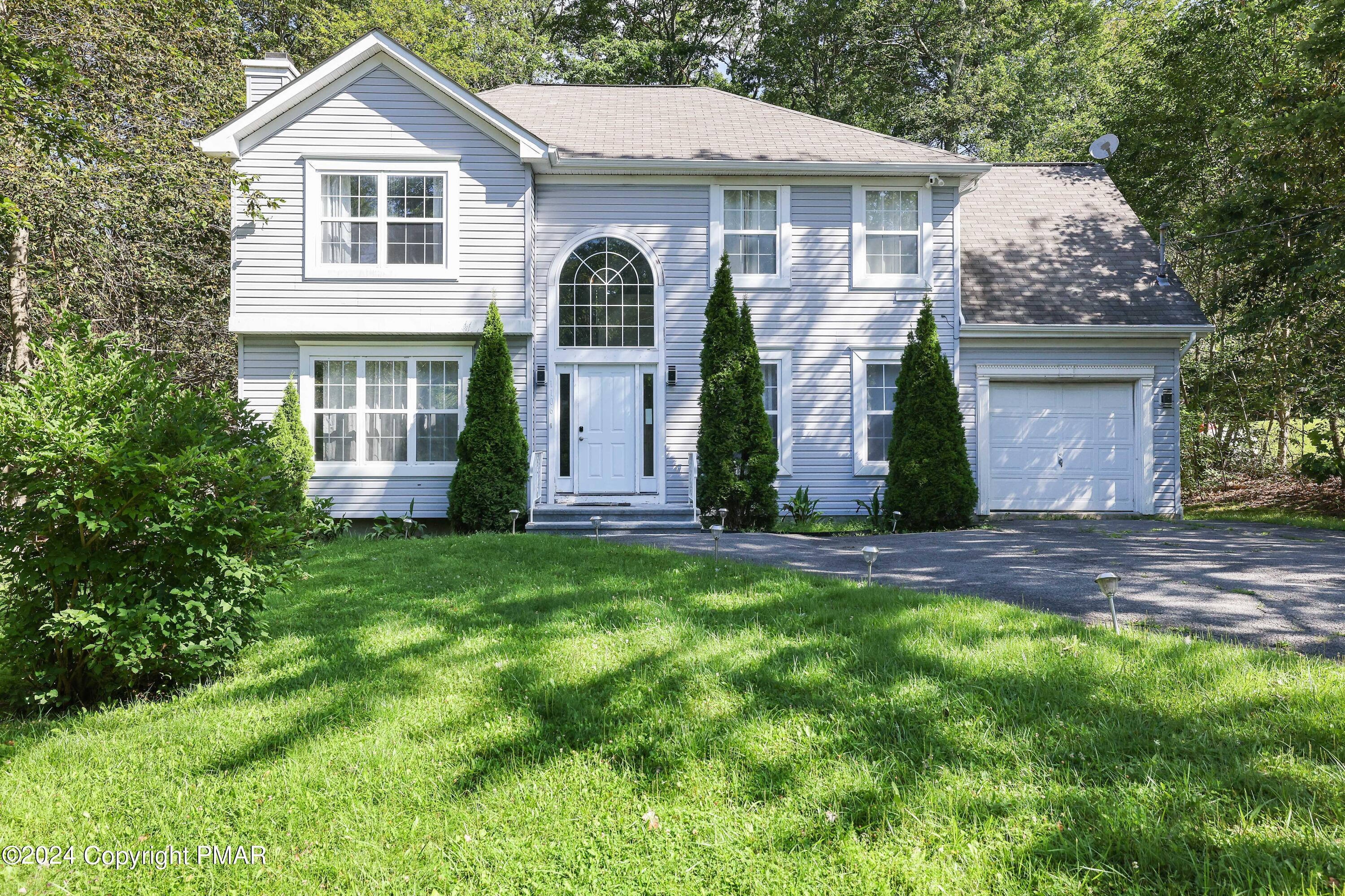 a front view of a house with a yard and garage