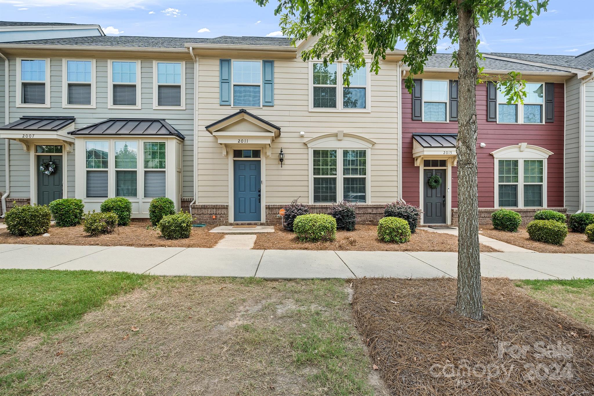 front view of a brick house with a small yard