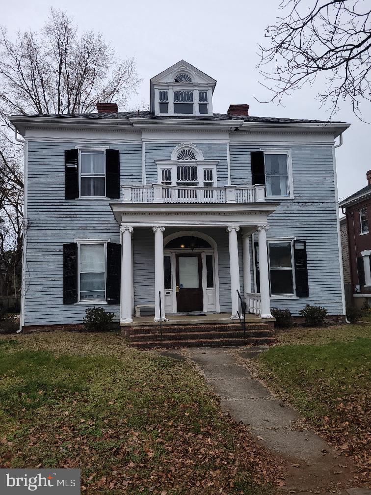 a view of a white house with large windows and yard