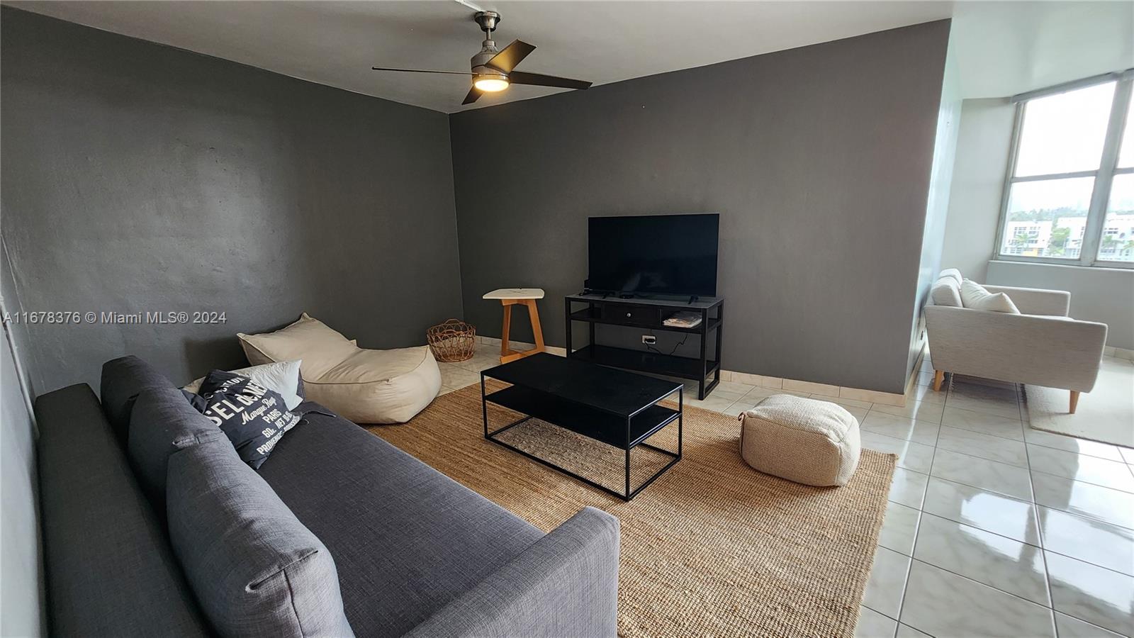 a living room with furniture a flat screen tv and a large window