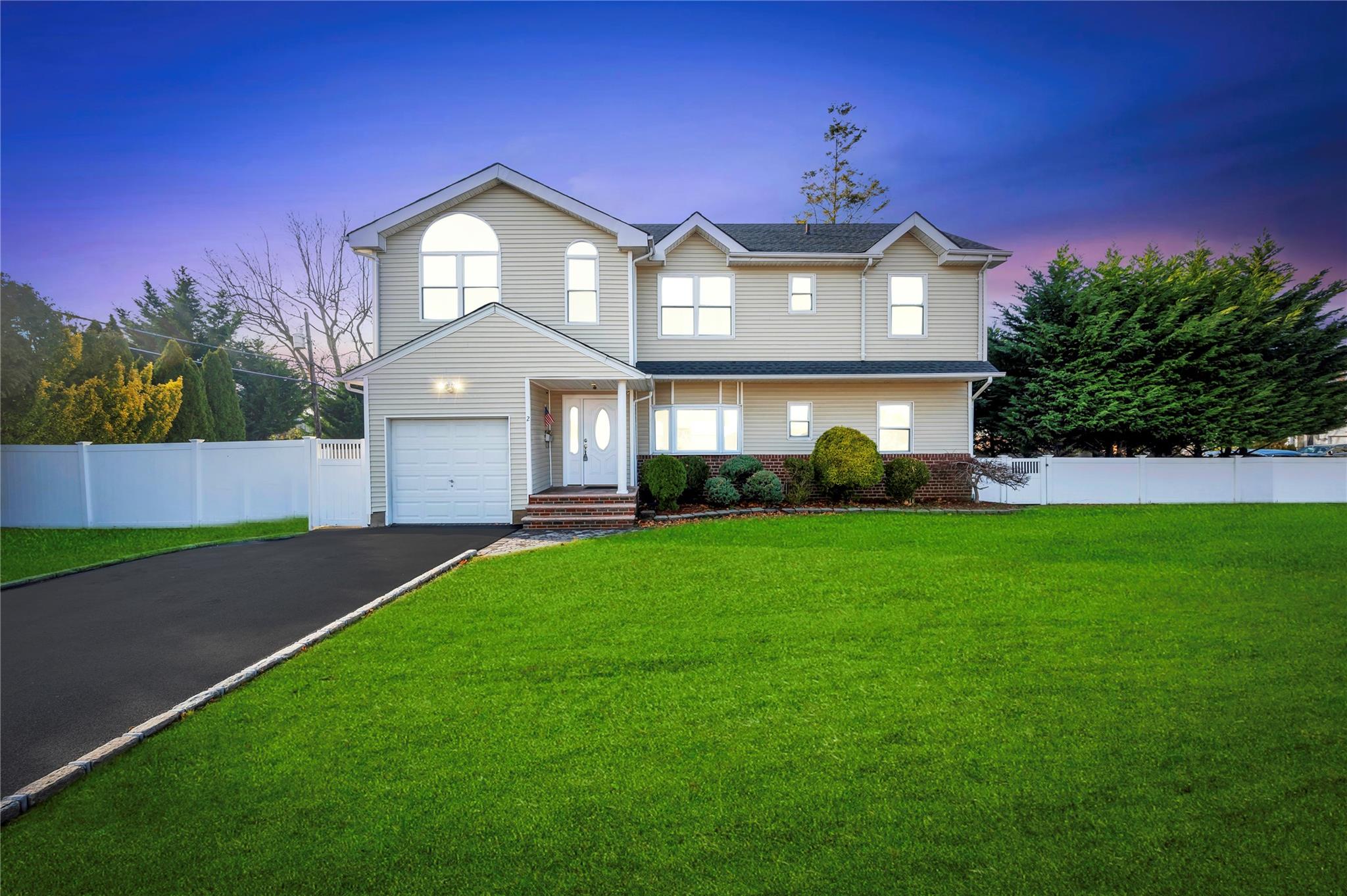 View of front property featuring a lawn and a garage