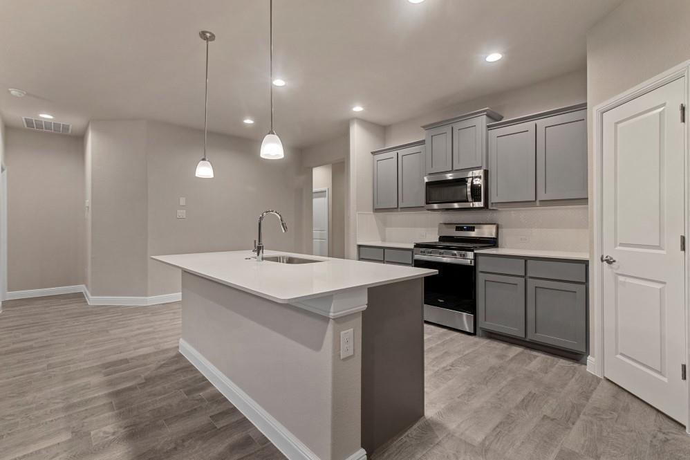 a kitchen with kitchen island a sink appliances and cabinets