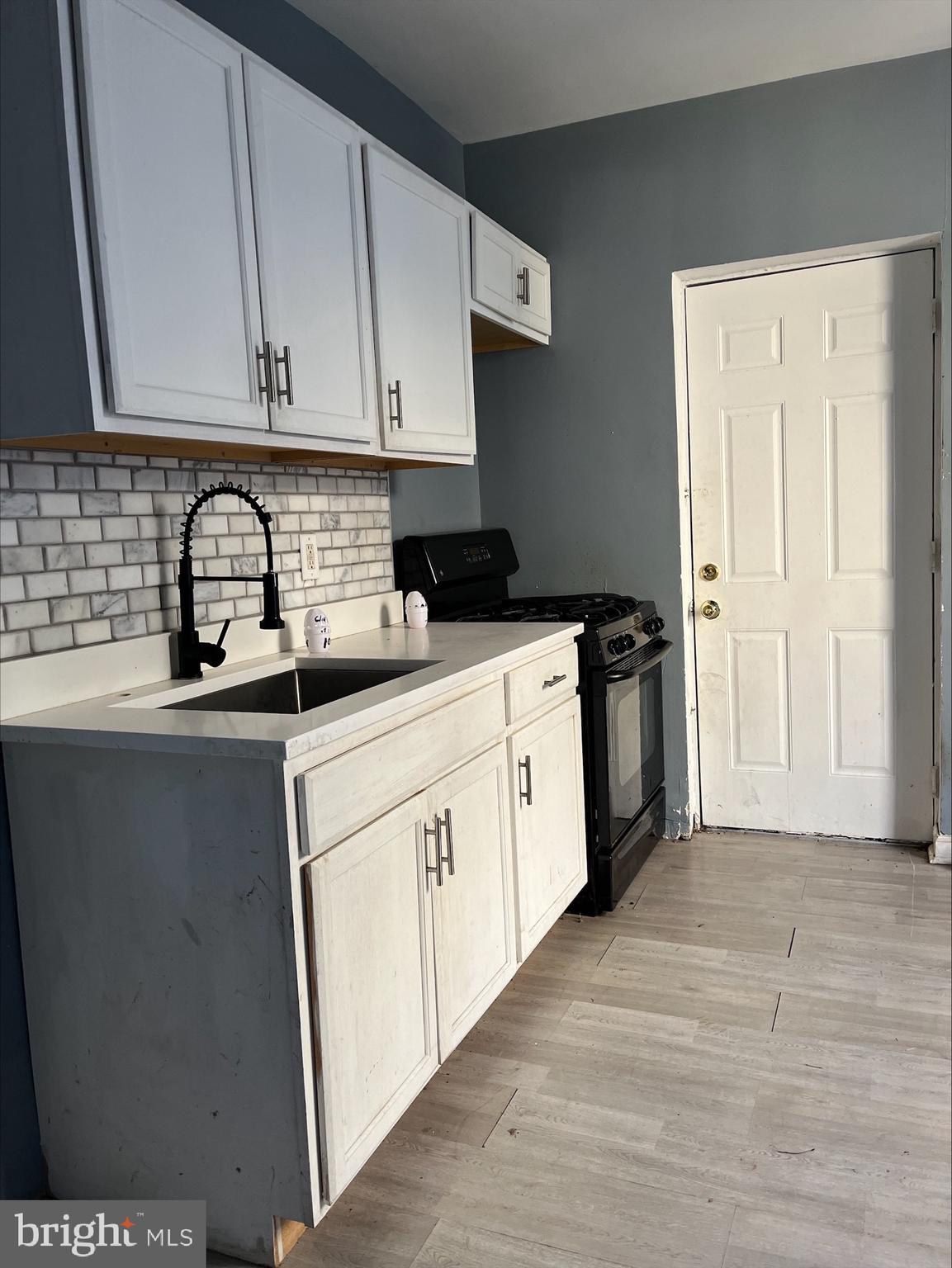 a kitchen with stainless steel appliances granite countertop a sink and cabinets with wooden floor