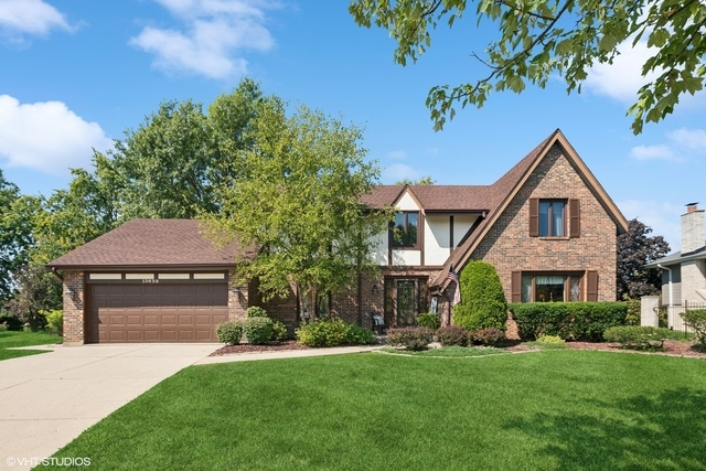 a front view of a house with a garden and plants