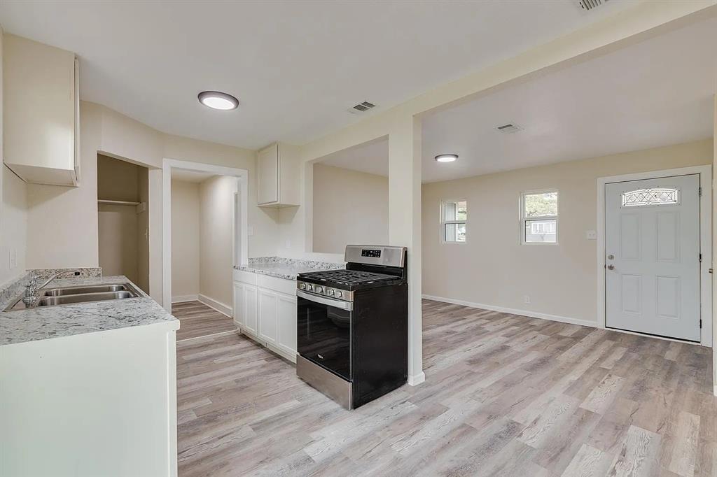 a kitchen with granite countertop a stove and a sink