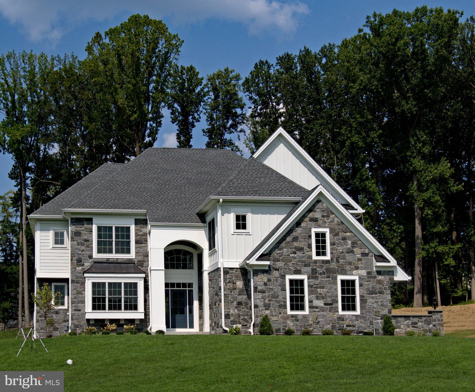 a front view of a house with a garden and trees