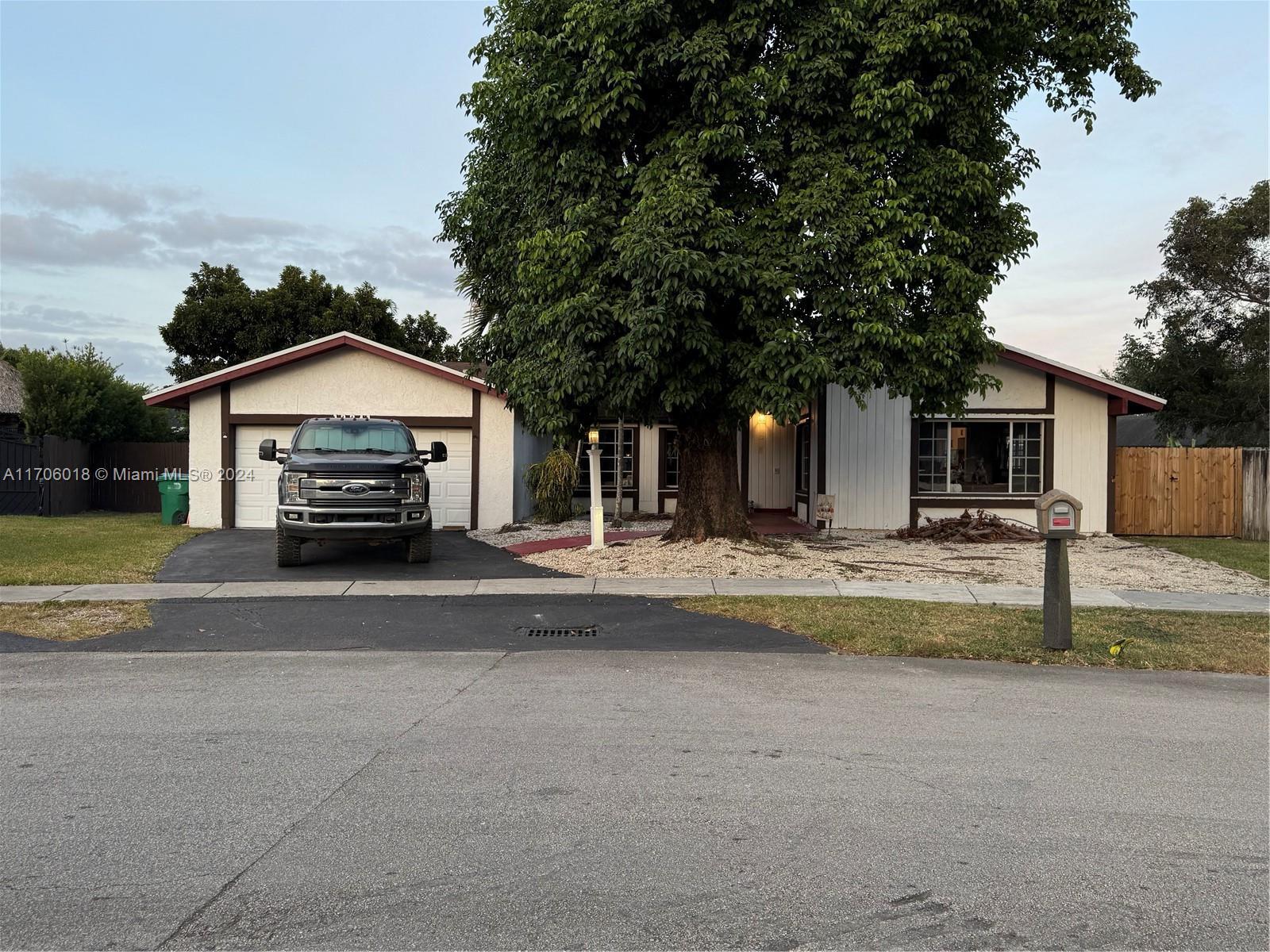 a view of house with outdoor space and parking