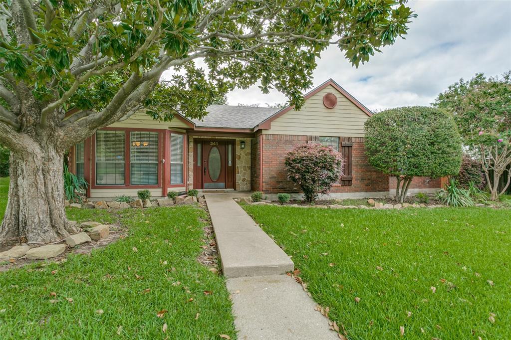 a front view of a house with yard and green space