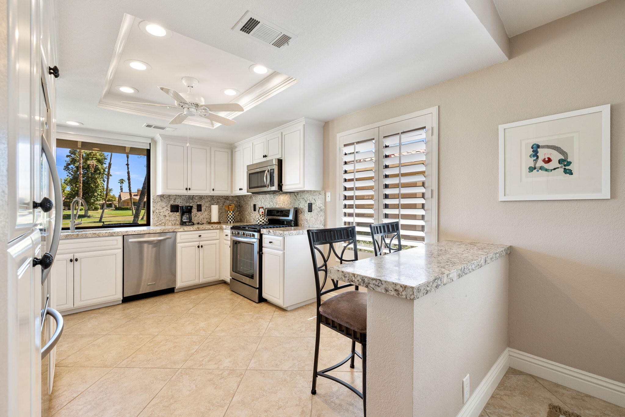 a kitchen with furniture a window and stainless steel appliances