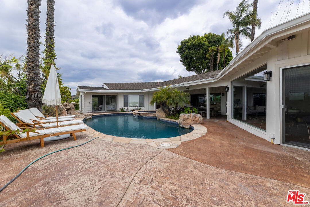 a view of a house with swimming pool and sitting area