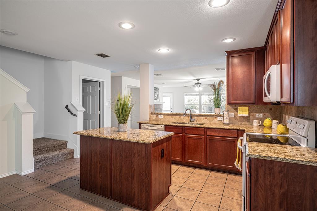 a kitchen with a sink a stove a refrigerator and cabinets