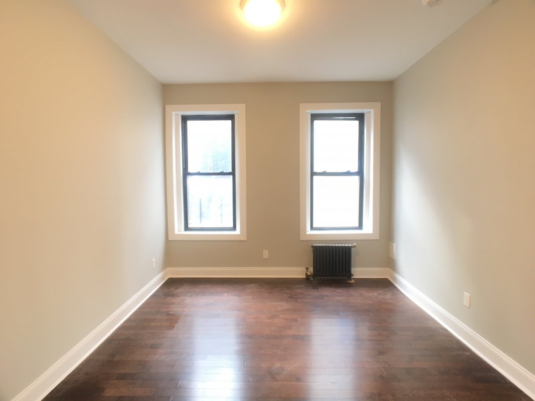 a view of a room with wooden floor and windows